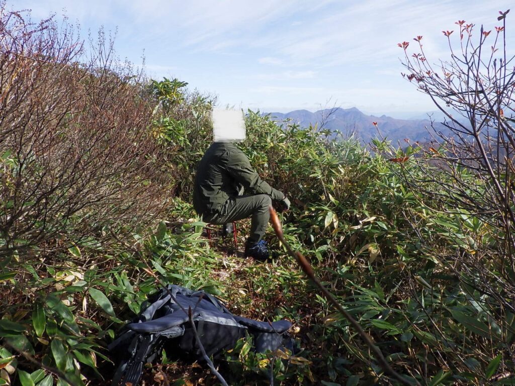 登山用椅子に座って景色を眺める